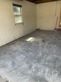 Empty room with concrete floor and a single window letting in natural light.