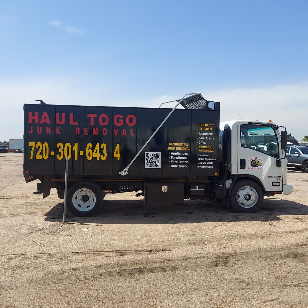 Junk removal truck with "Haul To Go" branding and contact information.